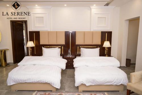 three beds in a room with white sheets and pillows at La Serene Hotel and Resort Kalam by Khan Familia Travels in Kalām