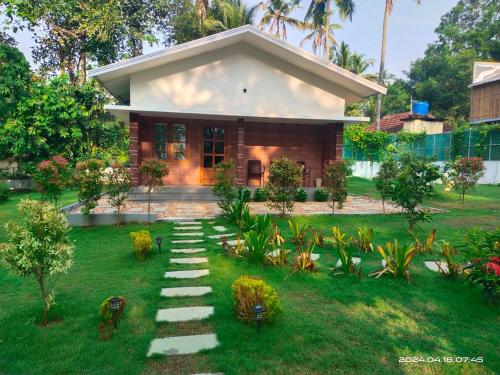 a house with a pathway in front of it at Merlys Fruit Garden in Cochin