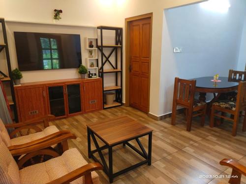 a living room with a table and a dining room at Merlys Fruit Garden in Cochin