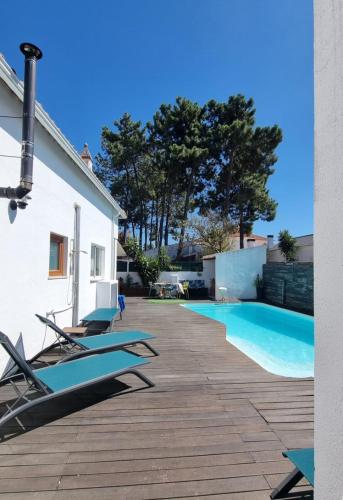 a swimming pool with lounge chairs next to a house at House of Arts in Corroios
