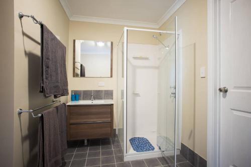 ein Bad mit einer Dusche und einem Waschbecken in der Unterkunft Nutcrackers Lodge in Esperance
