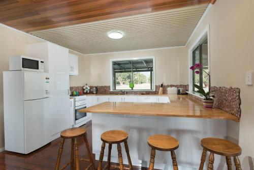 a kitchen with a counter and stools in it at Nutcrackers Lodge in Esperance