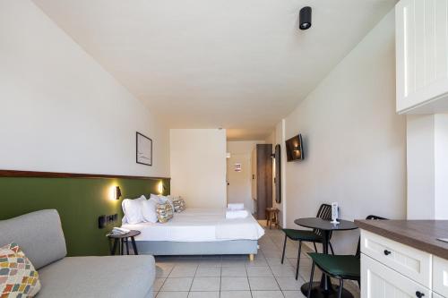 a hotel room with a bed and a couch at Aristea Hotel in Rethymno Town