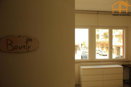 a room with a window with aania sign on the wall at Homes in Ancona CCA23 Rooms in Ancona
