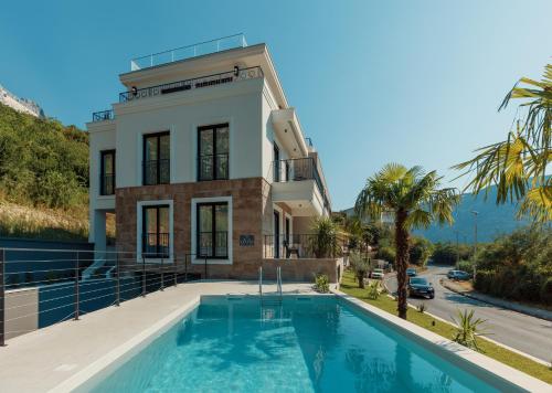 a house with a swimming pool in front of a building at S Palace Apartment in Kotor