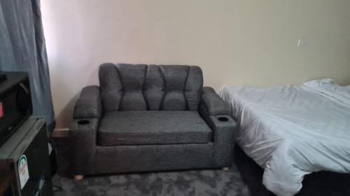 a chair sitting next to a bed in a room at Nashville Homes in Ongata Rongai 