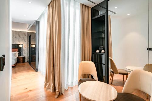 a living room with a table and chairs and a bathroom at Vincci Selección Unuk 5 GL in Seville