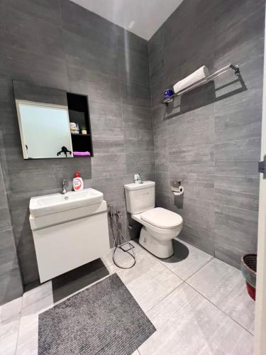 a bathroom with a toilet and a sink and a mirror at LoFF Suite River View 2 Bedroom at Kuching Riverine Resort in Kuching