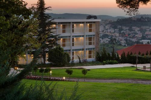 a building with a green lawn in front of it at Ye'arim Hotel in Maale Hachamisha