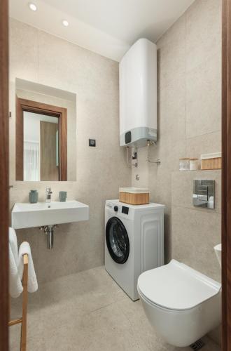 a bathroom with a washing machine and a sink at S Palace Apartment in Kotor