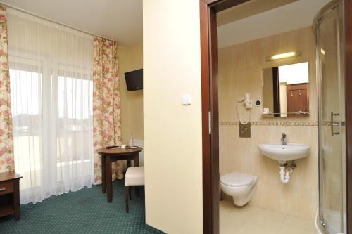 a bathroom with a toilet and a sink at Hotel Lotos in Woskrzenice Duże