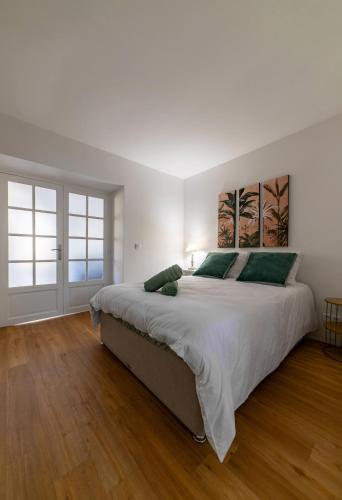 - une grande chambre blanche avec un grand lit et du parquet dans l'établissement Le Celestin - Appartement 2 chambres avec jardin en centre ville, à Vichy
