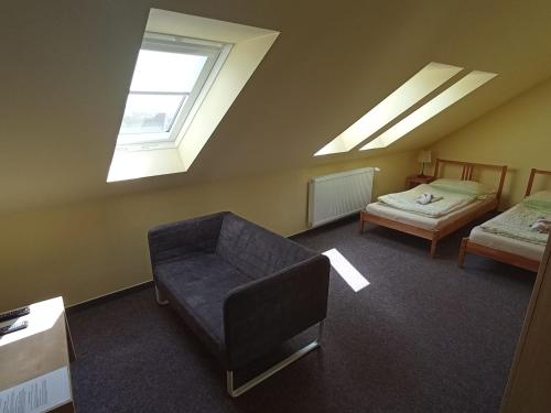 a room with a couch and a bed with skylights at Sport - Relax Buky in Františkovy Lázně