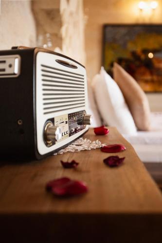 a radio sitting on top of a table with roses at Karlık Cave Suite Cappadocia in Uchisar