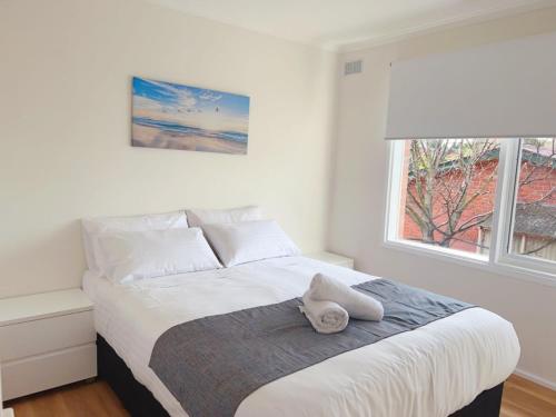 a bedroom with a bed with a stuffed animal on it at Sunny Retreat House in Hobart