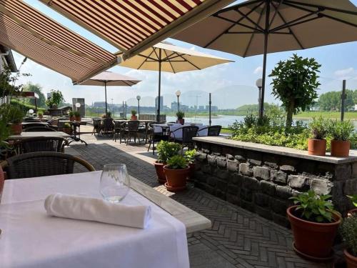a restaurant with tables and umbrellas on a patio at Valuas in Venlo