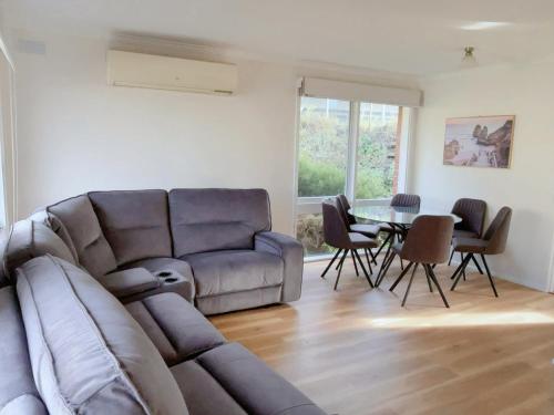 a living room with a couch and a table at Sunny Retreat House in Hobart