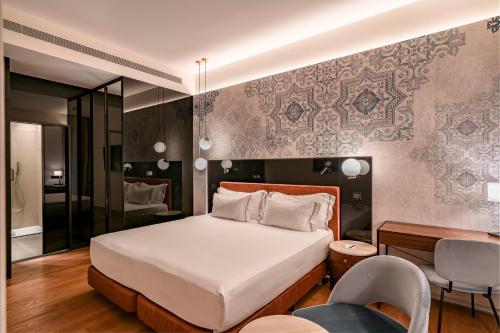 a bedroom with a bed and a table and chairs at Vincci Selección Unuk 5 GL in Seville
