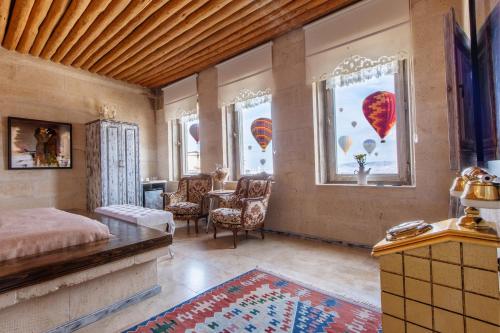 a bedroom with a bed and windows with balloons at Karlık Cave Suite Cappadocia in Uchisar
