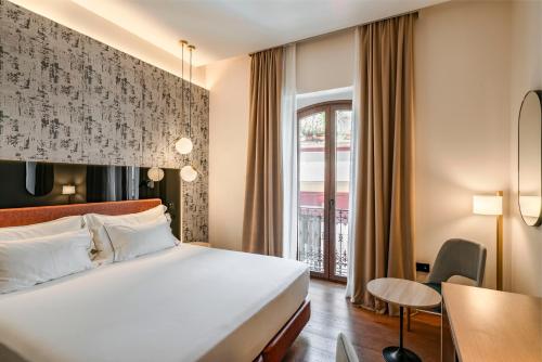 a hotel room with a bed and a table at Vincci Selección Unuk 5 GL in Seville