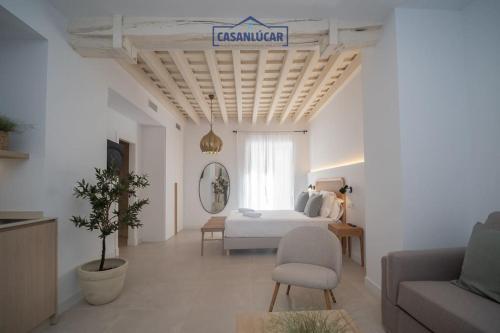 a room with a bed and a couch and a table at Sanlucar Centro - Apartamento 1 in Sanlúcar de Barrameda