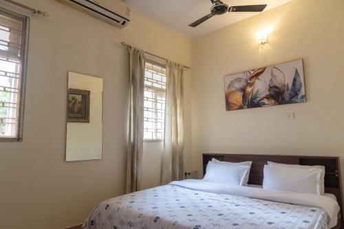 Un dormitorio con una cama y dos ventanas. en The Urban Grandeur 1, en Guwahati