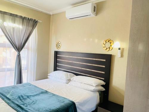a bedroom with a bed and a window at Druza’s guest house in Rustenburg