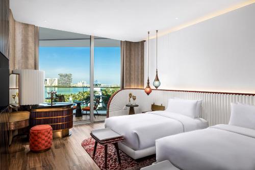 a hotel room with two beds and a balcony at W Dubai - Mina Seyahi in Dubai