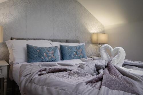 a bedroom with a large white bed with blue pillows at The Place by Sasco in Blackpool