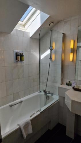 a bathroom with a bath tub and a sink at Hotel Du Parc - Mulhouse Centre in Mulhouse