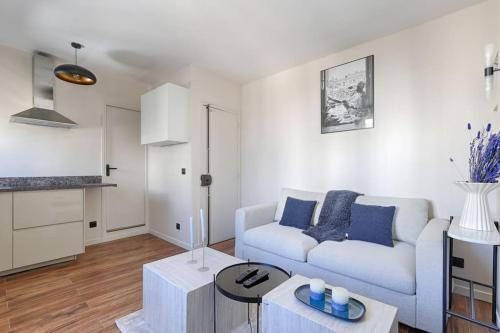 un salon avec un canapé blanc et une table dans l'établissement Daumesnil Nation Charming Lovely Studio, à Paris