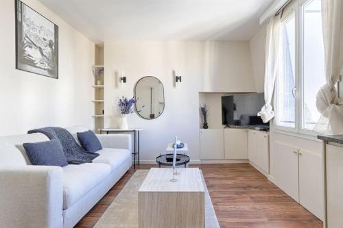 un salon blanc avec un canapé et une table dans l'établissement Daumesnil Nation Charming Lovely Studio, à Paris