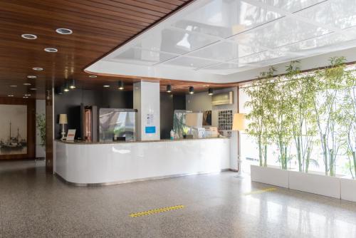 a lobby of a building with a counter with plants at Hotel Costa de Prata 2 & Spa in Figueira da Foz