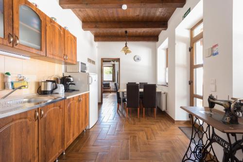 a kitchen with wooden cabinets and a wooden floor at Fehér Galamb Vendégház in Tolmacs