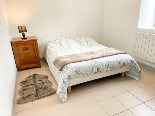 a small bedroom with a bed and a night stand at Maison de campagne paisible in La Mesniere