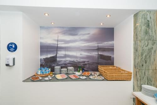 a plate of food on a wall with a painting at Hotel Costa de Prata 2 & Spa in Figueira da Foz