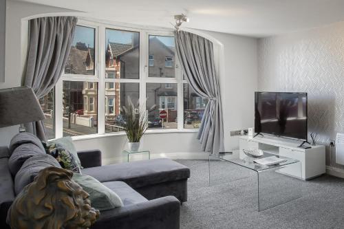 a living room with a couch and a tv at The Place by Sasco in Blackpool