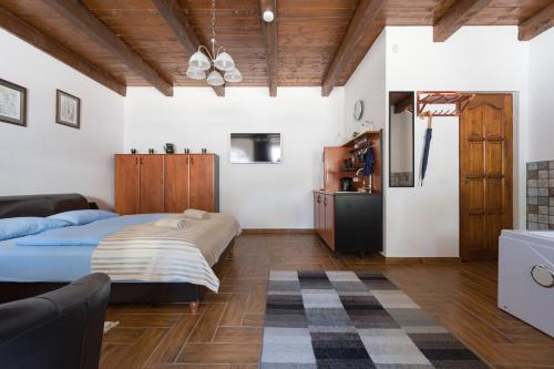 a bedroom with a large bed and a couch at Fehér Galamb Vendégház in Tolmacs