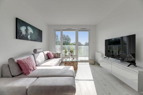 Televízia a/alebo spoločenská miestnosť v ubytovaní Przystań Letnica by Comfort Apartments