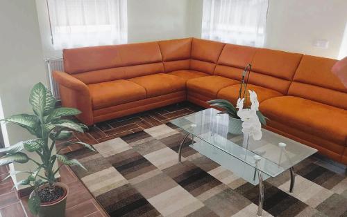 a living room with a couch and a glass table at Fehér Galamb Vendégház in Tolmacs