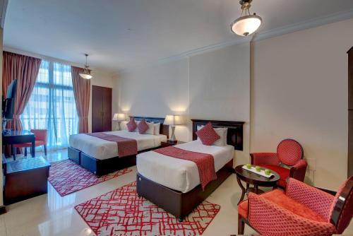une chambre d'hôtel avec deux lits et un salon dans l'établissement City Stay Premium Hotel Apartments, à Dubaï