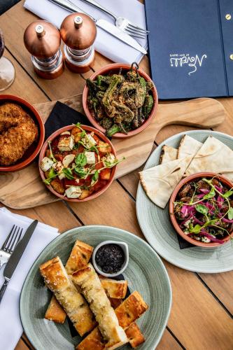 a wooden table with plates of food on it at AC Hotel by Marriott Belfast in Belfast