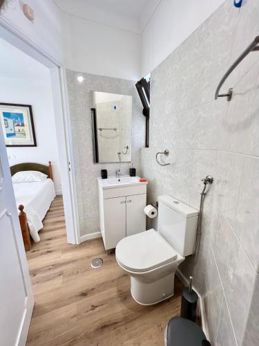 a white bathroom with a toilet and a sink at Vila Sophia, Vilamoura- By Urbinvest Algarve in Vilamoura