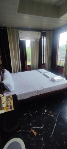 a large bed in a room with two windows at Sukh Sagar Hotel in Jaipur
