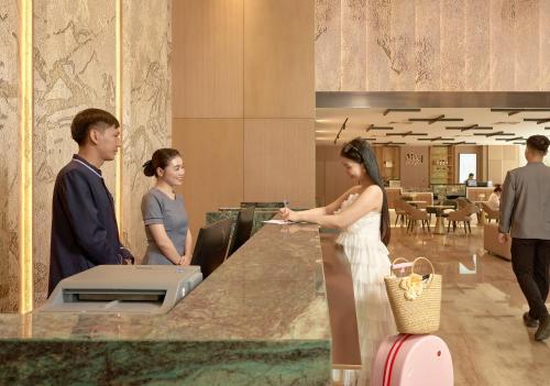 a bride and groom standing at a counter in a restaurant at Adamas Boutique Hotel Nha Trang in Nha Trang