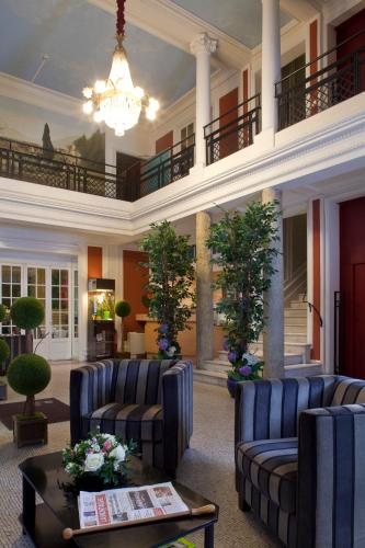 a large lobby with couches and a chandelier at Logis Le Midland in Vichy