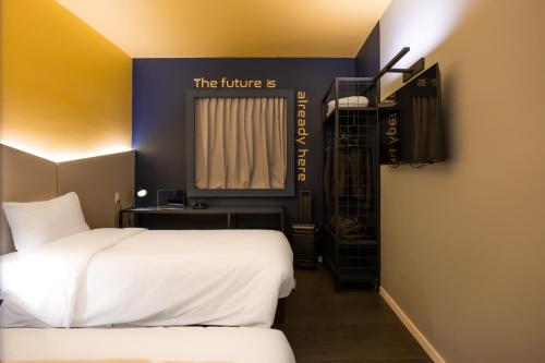 a hotel room with two beds and a window at Ibis Styles Barretos in Barretos