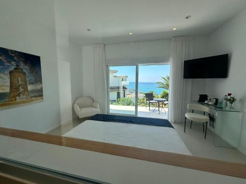a bedroom with a bed and a view of the ocean at Tierratlanta Suites in Zahara de los Atunes
