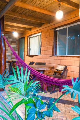 a hammock on the porch of a house at Pousada Flor de Maio - Vila De São Jorge in Sao Jorge