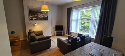 a living room with a couch and chairs and a table at Alexandra Park Apartments in Belfast